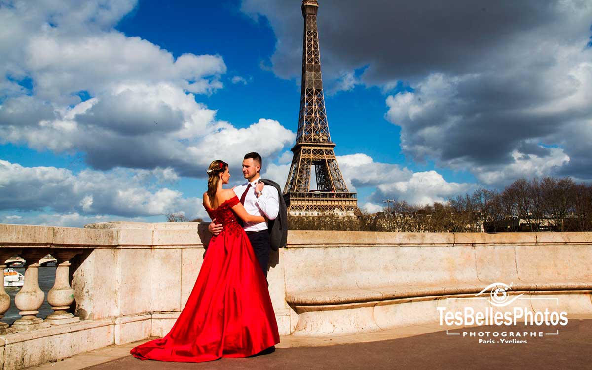 Photo de couple en tenue de mariés avec la robe luxe rouge de soirée de mariage à Paris Pont de Bir-Hakeim